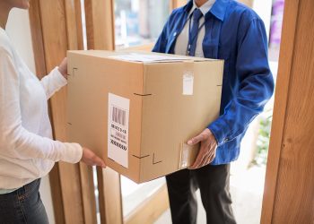 Delivery man bringing big package to the customers door