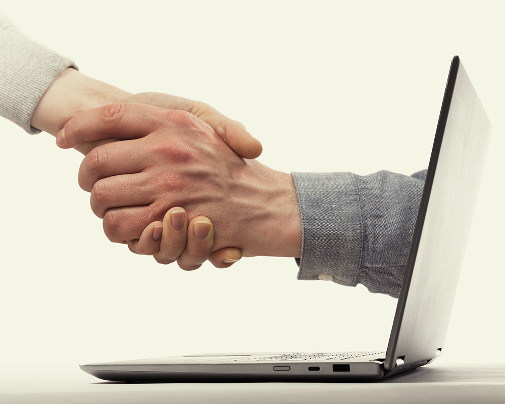 A deal between two partners from the laptop. Modern technology in business.